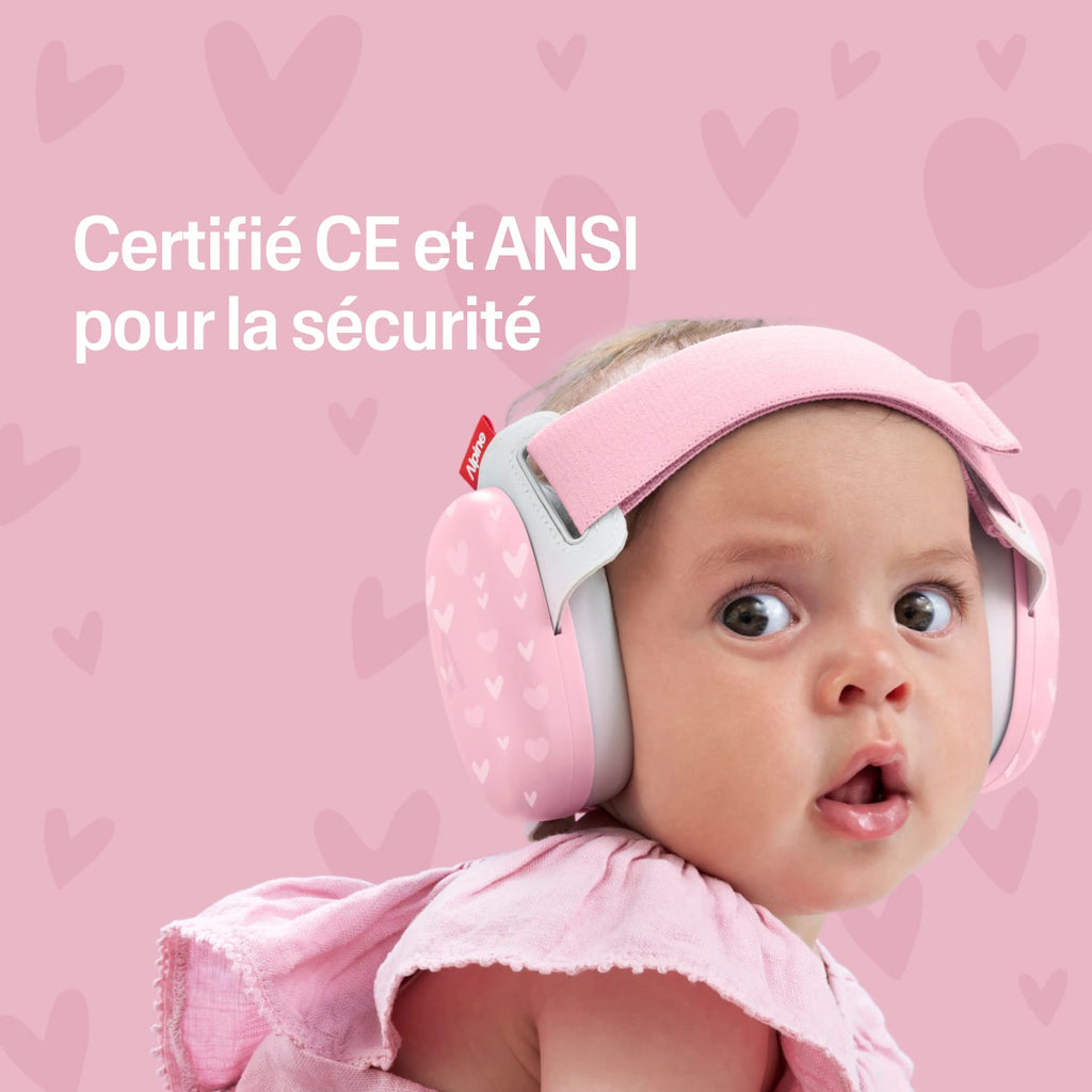 Baby wearing a pink muffy baby with certification text on a pink heart-patterned background #lang_fr #color_special-edition-sweet-hearts