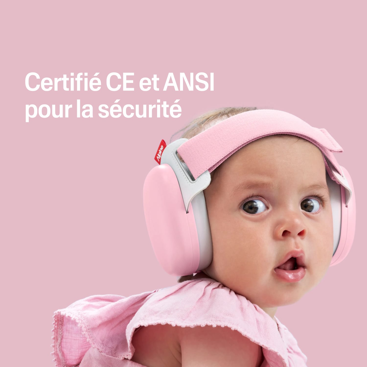 Baby wearing a pink muffy baby with certification text on a pink heart-patterned background #lang_fr #color_rose-pink