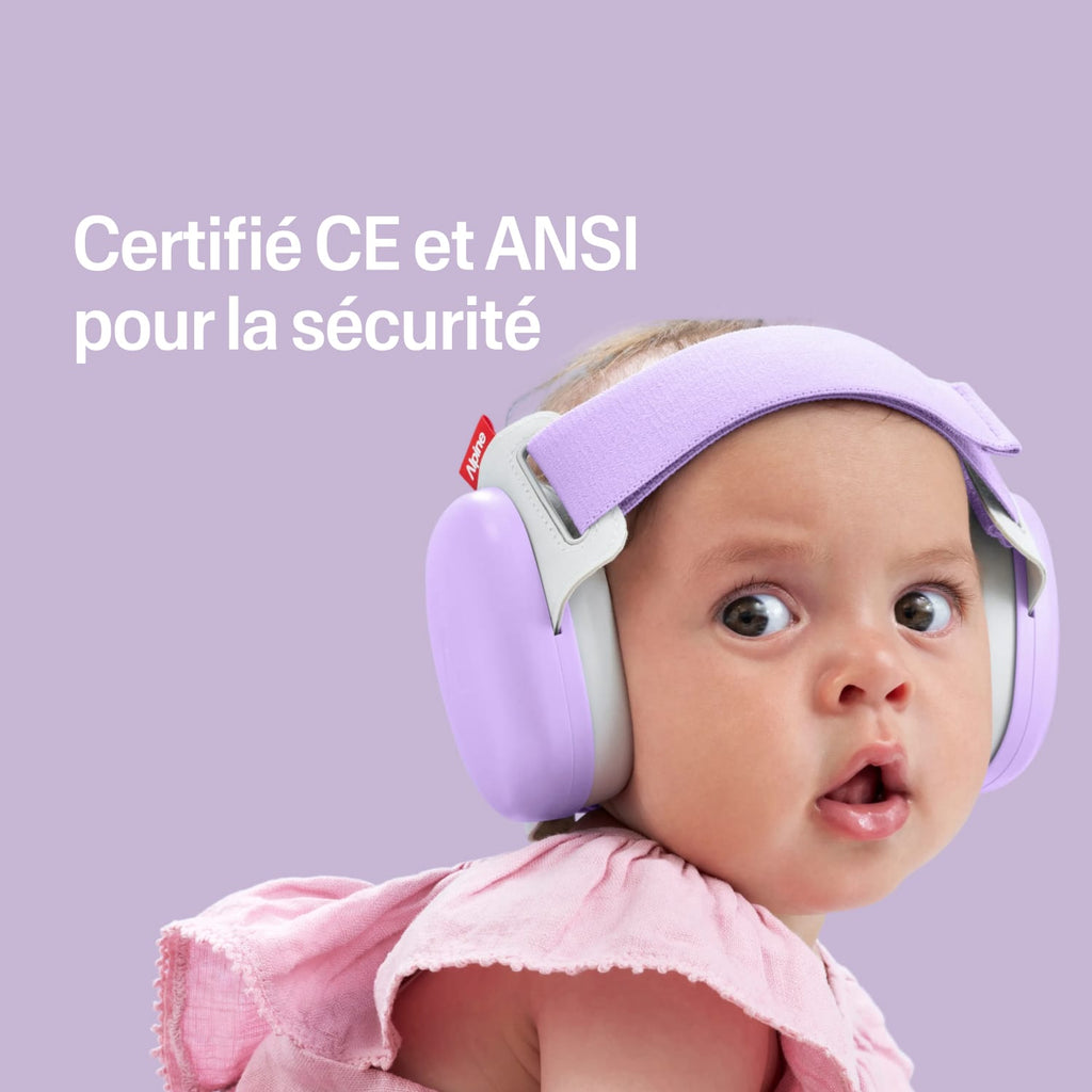 Baby wearing a purple muffy baby with certification text on a pink heart-patterned background #lang_fr #color_dawn-purple
